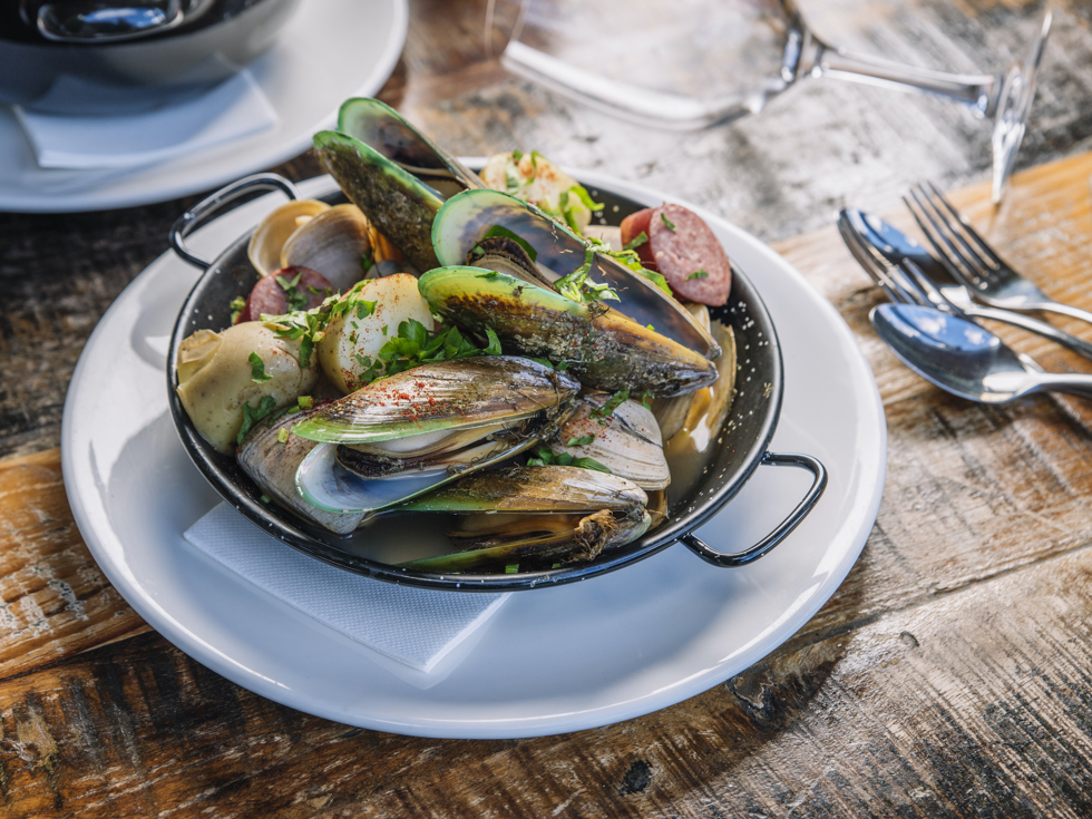 A plate of fresh local Greenshell mussels and clams served at Furneaux Lodge on the Queen Charlotte Track in the Marlborough Sounds, New Zealand.