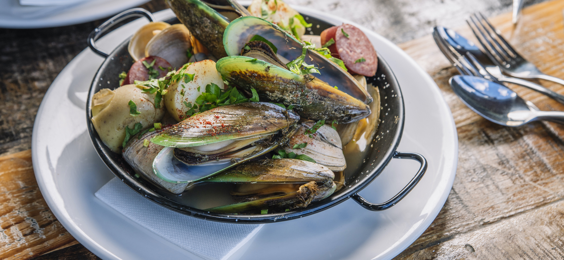 A plate of fresh local Greenshell mussels and clams served at Furneaux Lodge on the Queen Charlotte Track in the Marlborough Sounds, New Zealand.