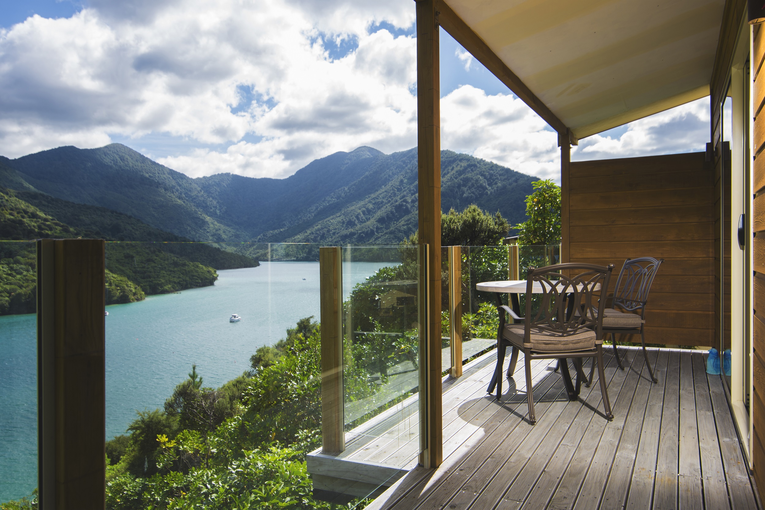 The private furnished balcony of a Frond Suite at Punga Cove has sweeping views across Endeavour Inlet in the Marlborough Sounds, New Zealand
