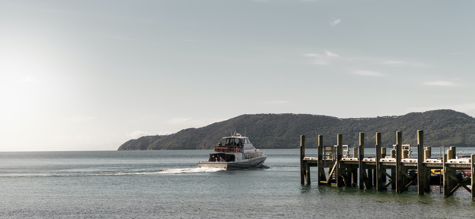 A Cougar Line boat departs the jetty at Ship Cove/Meretoto in the outer Queen Charlotte Sound/Tōtaranui in the Marlborough Sounds, New Zealand.