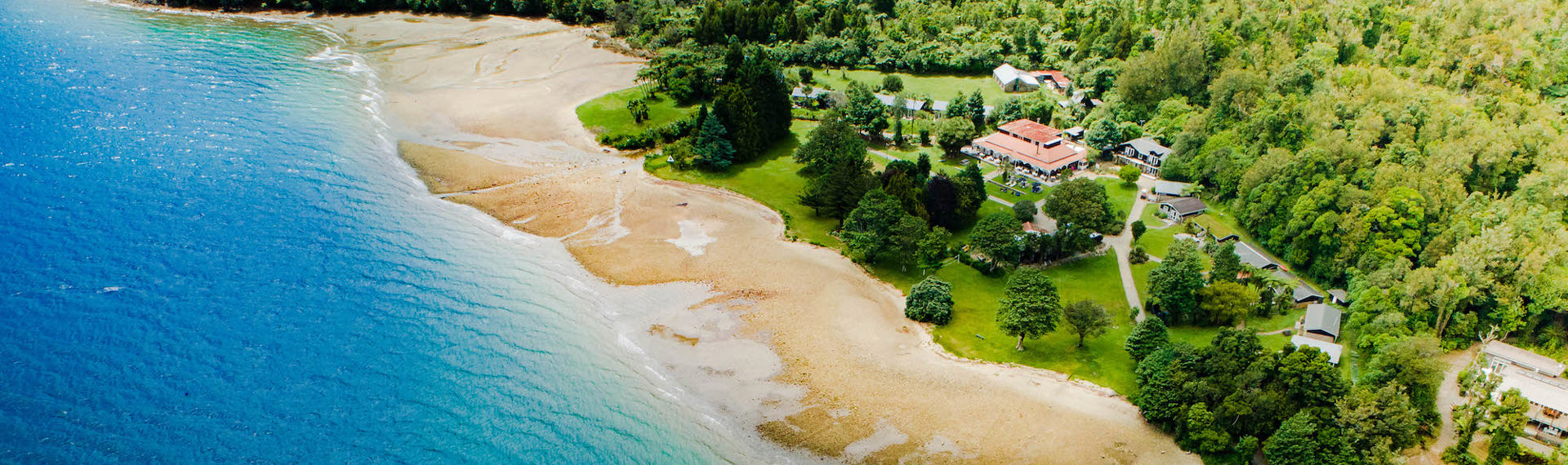 Aerial view of Furneaux Lodge across Endeavour Inlet and the jetty in the Marlborough Sounds, at the top of New Zealand's South Island.