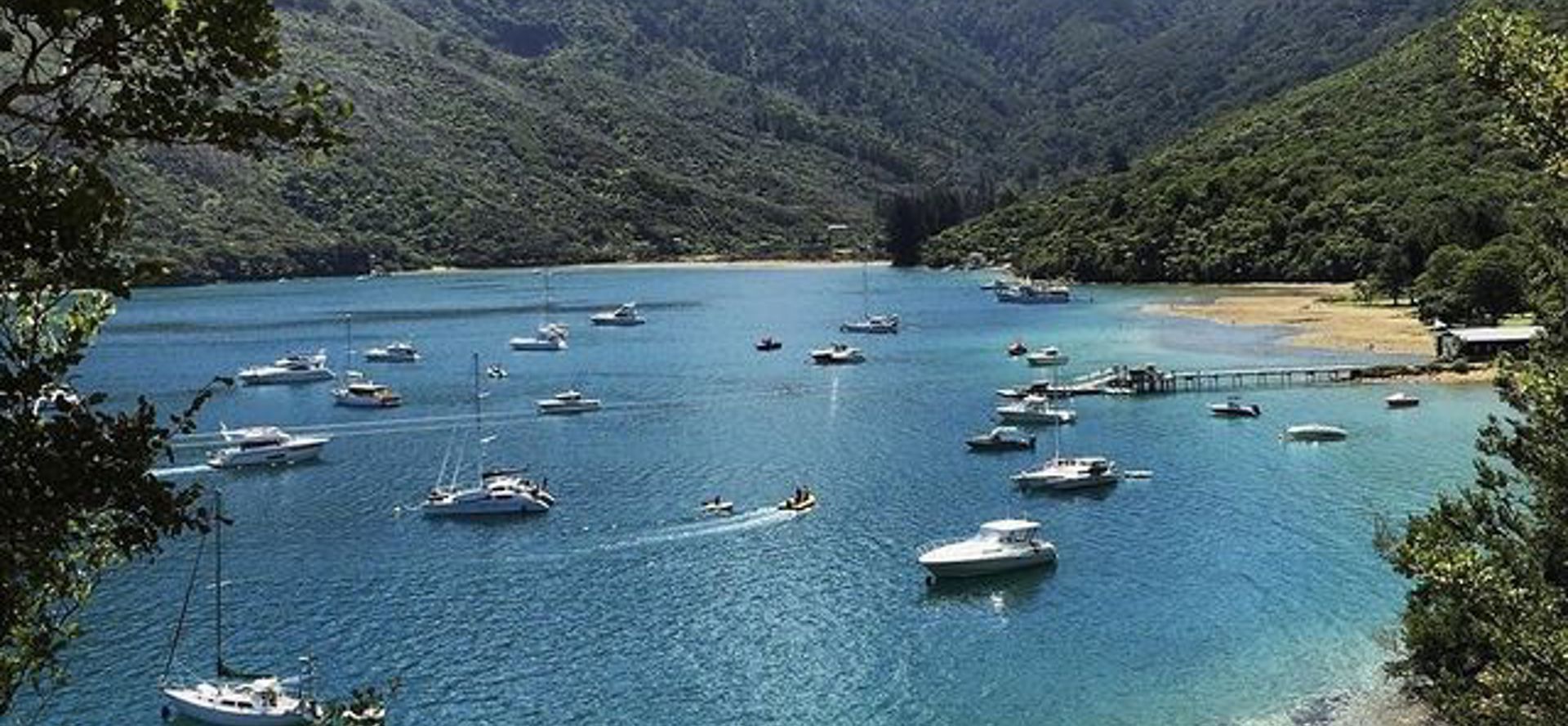 An aerial view of a Cougar Line boat and wake as it cruises through Queen Charlotte Sound/Tōtaranui in the Marlborough Sounds, New Zealand.