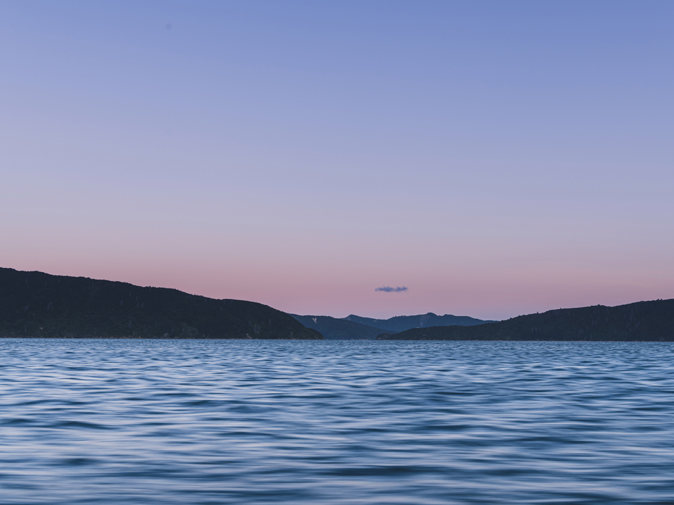 The Marlborough Sounds water, hills and full moon at sunset, Marlborough, New Zealand.