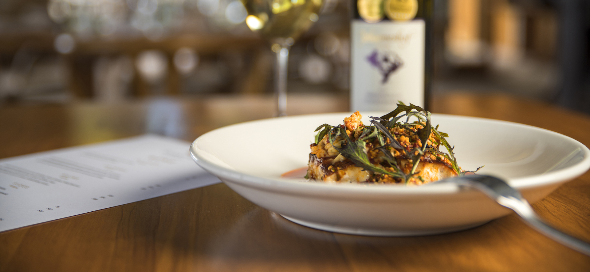 The Punga Fern Restaurant menu can include meals like this fresh Groper dish matched with a glass of local Marlborough wine at Punga Cove in the Marlborough Sounds of New Zealand's South Island