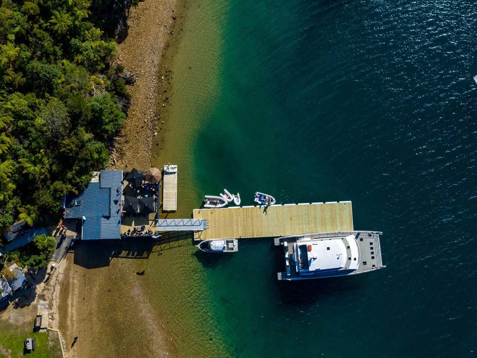 Boatshed Cafe and Bar and Punga Cove jetty shown from a birds eye view in the Marlborough Sounds in New Zealand's top of the South Island