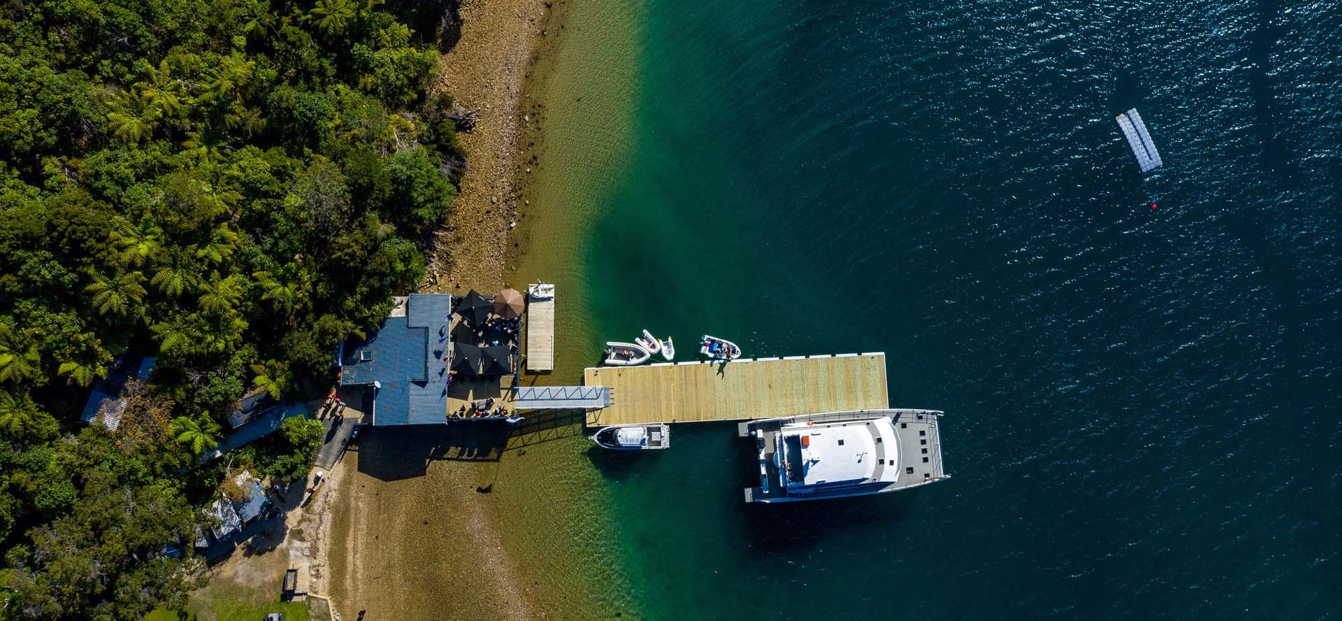 Boatshed Cafe and Bar and Punga Cove jetty shown from a birds eye view in the Marlborough Sounds in New Zealand's top of the South Island