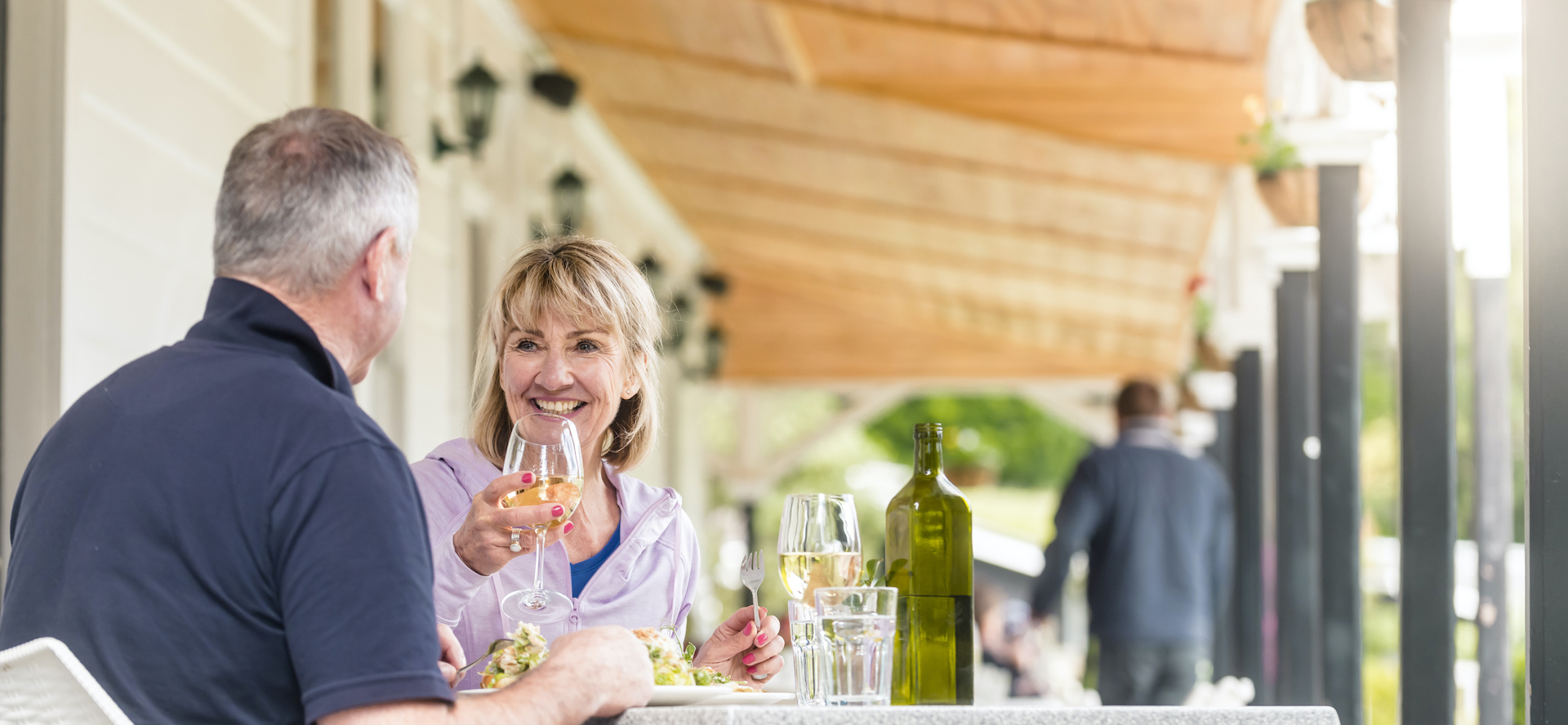 A couple dines at a table on the verandah at Furneaux Lodge in the Marlborough Sounds, New Zealand.